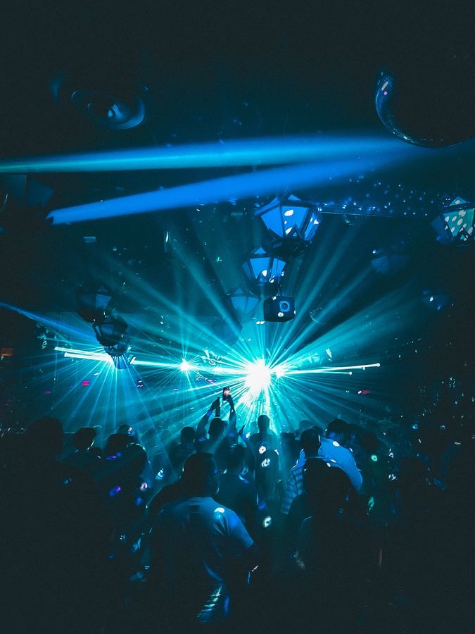 A crowd beneath blue beams of light