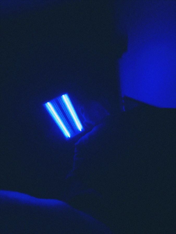 Two white lines of light on a phone screen in a deep blue room.