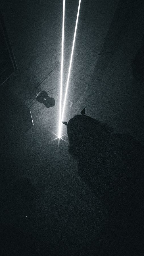 Two white laser beams slicing through a dark room.